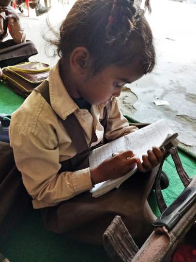 A little girl studies with her workbook.