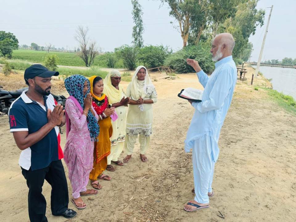 Pastor Charanjit Singh instructs a group of new believers before their baptism.